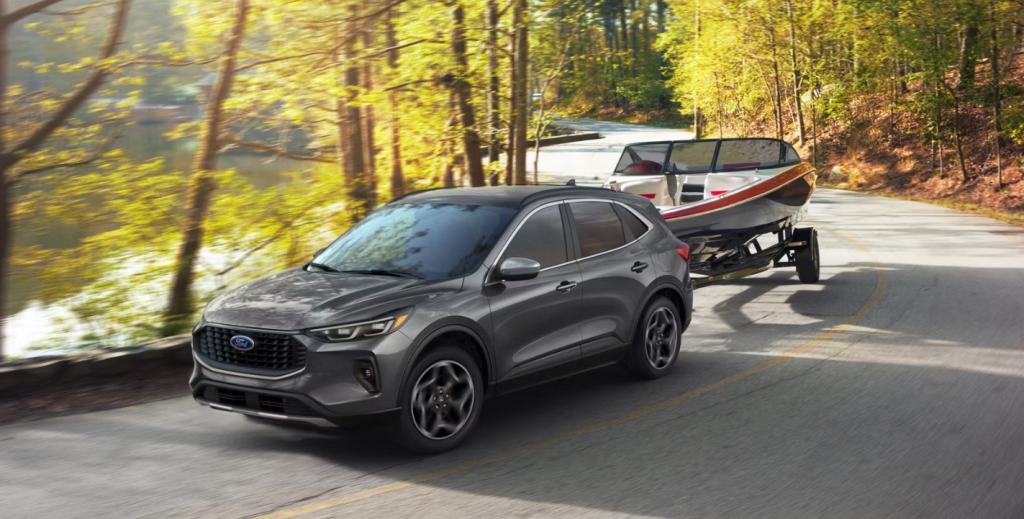 The 2026 Ford Escape tows a boat behind it on a windy road with a river next to it. Shop for your new 2026 Ford Escape at Ford of Spartanburg today.