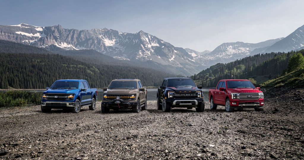 A lineup of new Ford trucks sits parked side by side with a mountain range in the background. Shop for your new 2026 Ford truck at Ford of Spartanburg today.